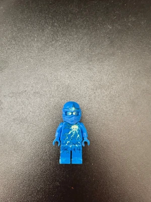 Blå LEGO Ninjago minifigur - Säljer en blå LEGO Ninjago minifigur med blixtmönster på bröstet och detaljerad mask. Figuren är tillverkad i plast och har rörliga armar och ben. Perfekt till samlingen eller för att bygga egna äventyr. Från 2012