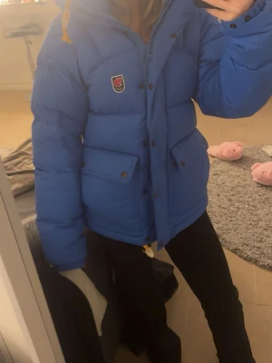 Blå dunjacka från Fjällräven - Säljer min Fjällräven i storlek xs. Köpte den i mitten på januari men säljer den för att den inte kom till så stor användning som ja trodde. Perfekt för kalla vinterdagar.💙som ny!