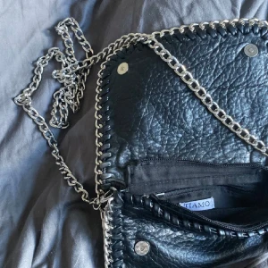 Svart axelväska från Tiamo - Snygg svart axelväska från Tiamo i skinn, inget synligt tecken på användning - väldigt fint skick. (köpte förra somman för 450kr)