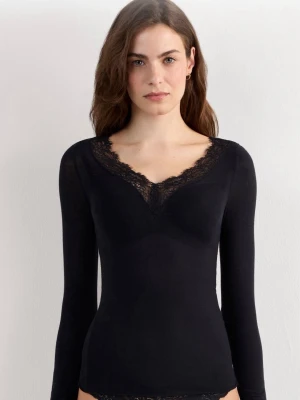 Svart långärmad instimissmi topp - Snygg svart långärmad topp med v-ringning och spetsdetaljer längs halsringningen. Figurnära passform som ger en stilren look. Perfekt att matcha med jeans. 