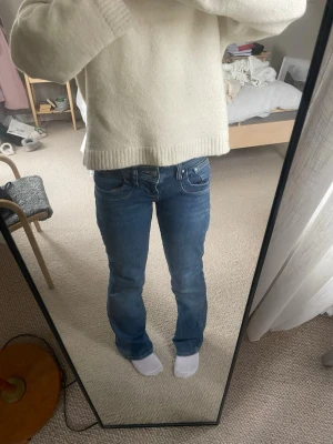 Blå jeans från LTB med utsvängda ben - Säljer ett par klassiska blå jeans från LTB med utsvängda ben och normal passform. Jeansen har snygga fickor, snygga sömmdetaljer och en midjehöjd som är låg samt som sitter bekvämt. Perfekta till vardags och lätta att matcha med olika stilar.