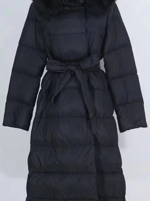 Svart lång dunjacka med bälte - Snygg svart lång dunjacka med bälte i midjan och stor krage. Jackan har quiltad design och långa ärmar, perfekt för kalla dagar. Enkel men stilren look som passar till det mesta.