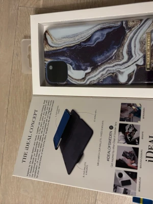 iDeal of Sweden marmormönstrat skal - Snyggt mobilskal från iDeal of Sweden med marmormönster i blått, vitt och brunt. Skalets material är hårdplast och har en guldfärgad detalj med logotypen. Passar perfekt för dig som vill ha ett trendigt och stilrent skydd till din iPhone.