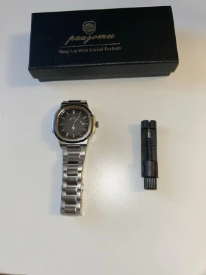 Pengarar silverfärgad klocka stål - Stilren klocka från Pengragar med silverfärgat armband i rostfritt stål och svart urtavla. Klockan har datumvisning, markerade index och en modern, fyrkantig boett. Perfekt accessoar för dig som gillar en clean och tidlös look.