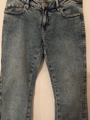 Blå jeans med kontrastsömmar - Snygga blå jeans med ljus tvätt och coola kontrastsömmar på bakfickorna. Klassisk femficksmodell med knapp och dragkedja. Perfekta för en avslappnad och trendig look.