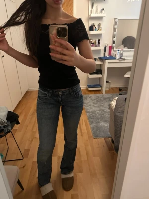 Blå bootcut jeans från h&m divided - Snygga blå bootcut jeans från  h&m divided med klassisk femficksdesign och lätt slitning. Jeansen har normal passform och är tillverkade i jeansmaterial. Perfekta för dig som gillar en tidlös och avslappnad stil.