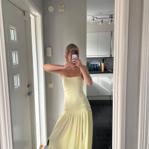Ljusgul långklänning med slits - Superfin ljusgul långklänning från peppermayo  med smala axelband och en snygg slits framtill. Otrolig till sommarens alla tillfällen men också perfekt till bal eller som bröllopsgäst!! Endast använd 1 gång. Slutsåld på hemsidan, nypris 950 kr. Har en liten lös söm på ryggen, se bild💕