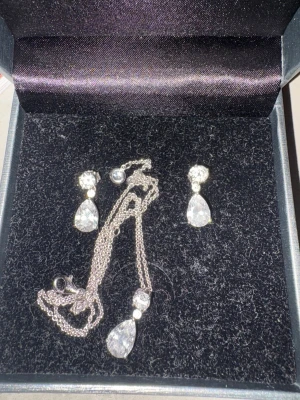 Vidal Vidal  - Bilderna visar ett smyckeset med halsband och örhängen i silver och kubisk zirkonia från Vidal & Vidal. Ingen väst finns på bilderna.