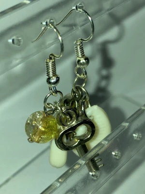 Unika örhängen med nyckel och snäcka - Ett par handgjorda örhängen med silverfärgade krokar, dekorerade med små metallnycklar, vita snäckor och gulfärgade pärlor. Mixen av material ger en cool och kreativ vibe, perfekt för dig som gillar statement-accessoarer. Frakt 22-100kr. Kontakta mig om du vill köpa eller har frågor.