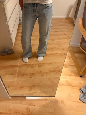 Levi's 512 ljusblå bootcut jeans - Klassiska ljusblå Levi's 501 jeans med bootcut passform och normal midja. Jeansen har fem fickor, knappgylf och den ikoniska röda Levi's-lappen bak. Tillverkade i slitstark bomullsdenim som ger en tidlös look.