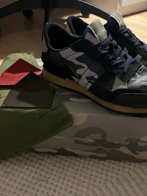 Valentino Rockrunners med allt og kvar! - Valentino rockrunners i riktigt snygg färgcombo med box, extra snören, 1 dustbag och två små äkthetskort som följer med! Smått creasade men inget man märker, riktigt snygga och eftertraktade! Nypris: ca 9000.  Använda men i bra skick! Finns slitage på insidan i hälen vid ena skon men jag tycker verkligen inte det känns! Hör av er vid frågor,