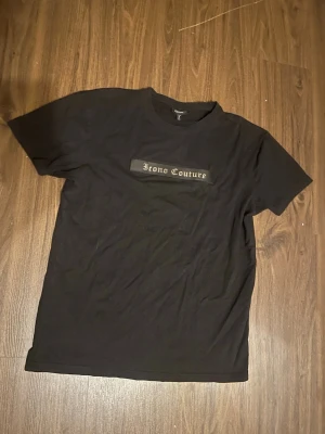 Svart Icono Couture t-shirt XL - Säljer en svart t-shirt från Icono Couture i storlek XL. T-shirten har klassisk passform, rund hals och tryck med texten 'Icono Couture' i silver på bröstet. Perfekt till streetwear-stilen och enkel att matcha med jeans eller shorts.