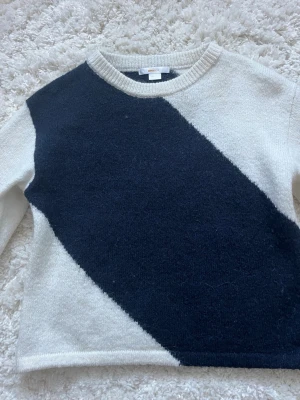Stickad tröja med diagonal färgblock Gina Tricot - Säljer en stickad tröja från Gina Tricot i storlek 134/140. Tröjan har ett snyggt diagonal färgblocksmönster i mörkblått och vitt, rund halsringning och långa ärmar. Perfekt för dig som gillar enkel men cool stil.
