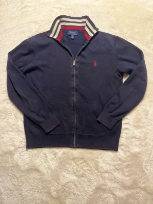 Ralph Lauren Zip - Hej! Säljer nu min Ralph Lauren fullzip tröja. Riktigt snygg. Köpt för cirka 1300 på kidsbrandstore. Hör av dig om du undrar något! Sitter som en XS. 
