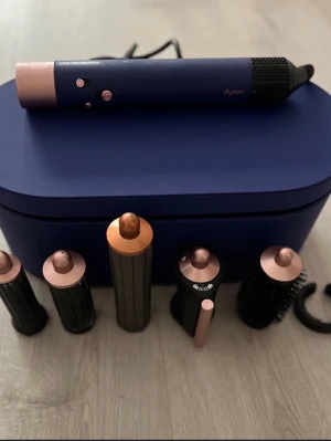 Dyson Airwrap multistyler - Säljer en blå Dyson Airwrap med flera stylingtillbehör i kopparfärg och svart.           Inköpt 2023 för 6399:-  Blue limited edition.  Använt men fint skick. Allt funkar problemfritt.  3 olika barell (dom är något skavda men inget som stör funktion) 2 korta och 1 lång i olika tum 1 rundborste 1 hårblå  Inkluderar alla tillbehör som syns på bilden
