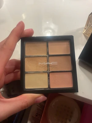 MAC concealerpalett med sex nyanser - MAC concealerpalett med sex olika krämiga nyanser i beige, gul och persikotoner. Perfekt för att täcka mörka ringar, blemmor och ojämnheter. Kommer i en svart fyrkantig plastförpackning med genomskinligt lock och MAC-logga. Färgen light