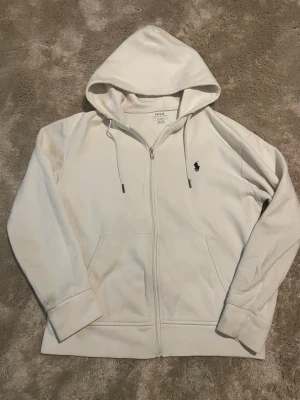 Vit raplh lauren zip - Säljer denna raplh lauren zip. Perfekt till vintern eller hösten. Jag är 178 cm lång och den passar mig perfekt. Inga defekter eller något. Skickas endast med PostNord. Om annat fraktsätt väljs av Plick, avbryts köpet.