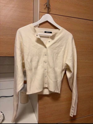 Stickad figursydd kofta - Jättefin kofta med knappar. Figursydd modell så sitter jättefint på. Använd fåtal gånger, lite nopprig men något som går att få bort. 