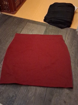 Röd kortkjol från Cubus  - Enkel och snygg röd kortkjol från C i storlek L. Kjolen har en rak passform och är tillverkad i ett mjukt material som känns bekvämt. Perfekt att matcha med en stickad tröja eller t-shirt för en clean look.