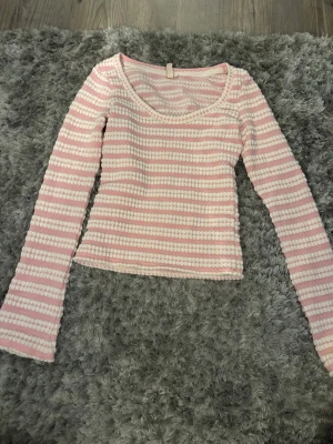 Rosa och vit randig topp från Nelly - Stickad tröja från nelly i storlek xxs. Säljer då den inte kommer till användning. 