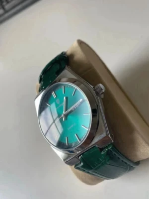 Poedagar herrklocka 41mm kvartz med läderband - Snygg klocka med grön urtavla och matchande grönt läderband med krokodilstruktur. Boetten är i silverfärgad metall. Perfekt accessoar för dig som vill sticka ut lite extra.