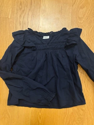 Marinblå blus från Kappahl med volanger.  - Marinblå blus från Kappahl med volanger. I storlek 152. 