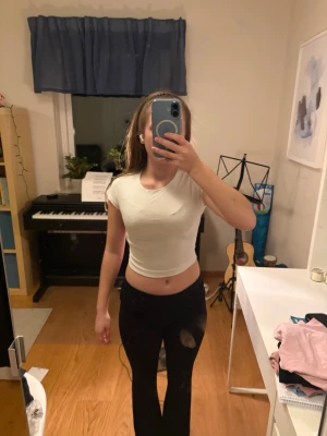 Vit croppad t-shirt från Zara - Säljer en enkel och fräsch vit croppad t-shirt från Zara. Modellen är tight med korta ärmar och rund halsringning. Super mjukt tyg och nästintill oanvänd. Passar mig som använder XS.