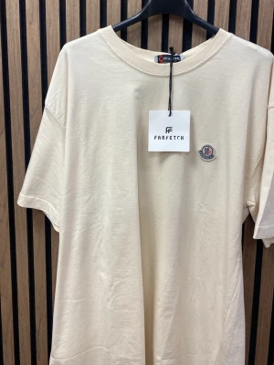 Beige t-shirt  - Snygg beige t-shirt  i mjuk bomull. Klassisk rund halsringning och korta ärmar. Perfekt för en clean och stilren look.