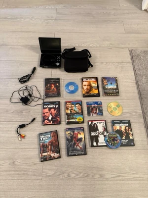 DMTECH PDV782US bärbar DVD-spelare - Säljer en portabel DVD spelare av märket DMTECH, modell PDV782US. Den har en 7” LCD-skärm. Följer med strömkabel, AV-kabel, väska och 13 filmer på DVD.  Hej! Säljer DMTECH Portabel DVD-Spelare med filmer som syns på bilden. Det som medföljer är -Strömsladd så man kan kolla inomhus -Strömsladd till bil (Cigarett uttag) -Kabel så man kan koppla den till TV’en -Väska till DVD-spelaren som man kan förvara den i & - -Finns uttag till hörlurar hänga upp på förar/passagerar sätet så ungarna där bak kan