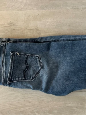 Replay blå slim fit jeans - Säljer ett par blå Replay jeans med passformen slim fit. Det är en snygg blå färg som faseas, byxorna är perfekt för dig som vill vara snygg i vardagen och även i helgen.