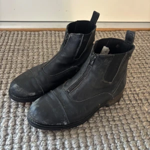 Svarta riskor med dragkedja - Säljer ett par svarta ridskor från JH Collection i storlek 38. De har lite ”repor” vid tårna men inget  verkar påverka funktionen☀️!