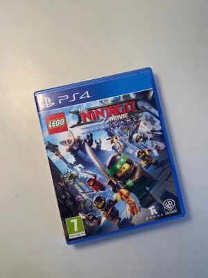 LEGO Ninjago  Videogame PS4 - LEGO Ninjago Movie Videogame till PS4 i mycket fint skick. Komplett med fodral, skiva och manual. Spela som din favoritninja och försvara Ninjago City i actionfyllda äventyr. Passar från 7 år. Perfekt för LEGO- och spelentusiaster!