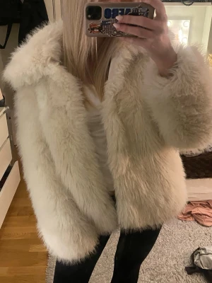 Vit fluffig pälsjacka - Säljer en supermjuk och fluffig vit pälsjacka med bred krage. Jackan är jättevarm och mysig och är i exemplariskt skick!💕nypris på denna är 2500kr därav den goda kvaliteten och priset! 