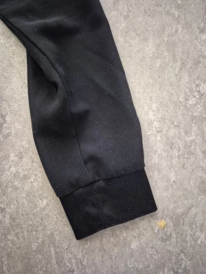 Jacka/Kofta - Svart jacka från KappAhl i klassisk modell med dragkedja framtill. Jackan har ribbade muddar vid ärmslut och midja, samt rundad krage. Tillverkad i ett mjukt material som känns skönt mot huden. Perfekt för dig som gillar en stilren och enkel look. Finns en fläck.