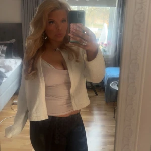 Vit kofta med lång ärm - Säljer en vit, croppad kofta med lång ärm och öppen framtill. Den är i one size från märket missay jätte bekväm och fin