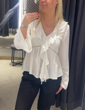 Vit blus med volanger och v-ringning - Säljer en vit blus med v-ringning och snygga volangdetaljer framtill. Den är från Kappahl och använd 1 gång. Nyskick. Pris kan diskuteras.
