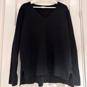 Svart stickad tröja - Svart stickad tröja från H&M storlek L! V-ringad och slits vid ärmslut och nertill på båda sidor💕 I gott skick!