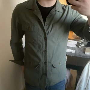 Olivgrön overshirt - Otroligt snygg grön overshirt. Modellen är 180cm, 73kg. Priset kan diskuteras!