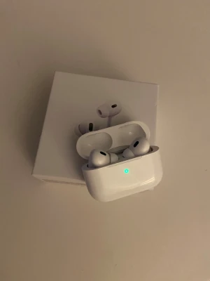 AirPods Pro - Snygga och välbevarade AirPods Pro med laddningsetui. Aktiv brusreducering, trådlös laddning och bekväm passform. Inga synliga repor eller skador, levereras med originalförpackning. Perfekt för musik, samtal och träning.