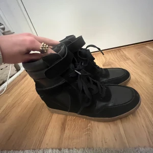 Klack-sneaker - Säljer ett par svarta mocka/skinn skor med klack i men känslan och utseende av sneakers. Säljer dessa skor för att dom inte passade mig i storleken men är i fint skick och använda 1-2 gnr i torrt väder så ingen skada eller repor! Om ni är intresserade av skorna så är det bara att skriva💕