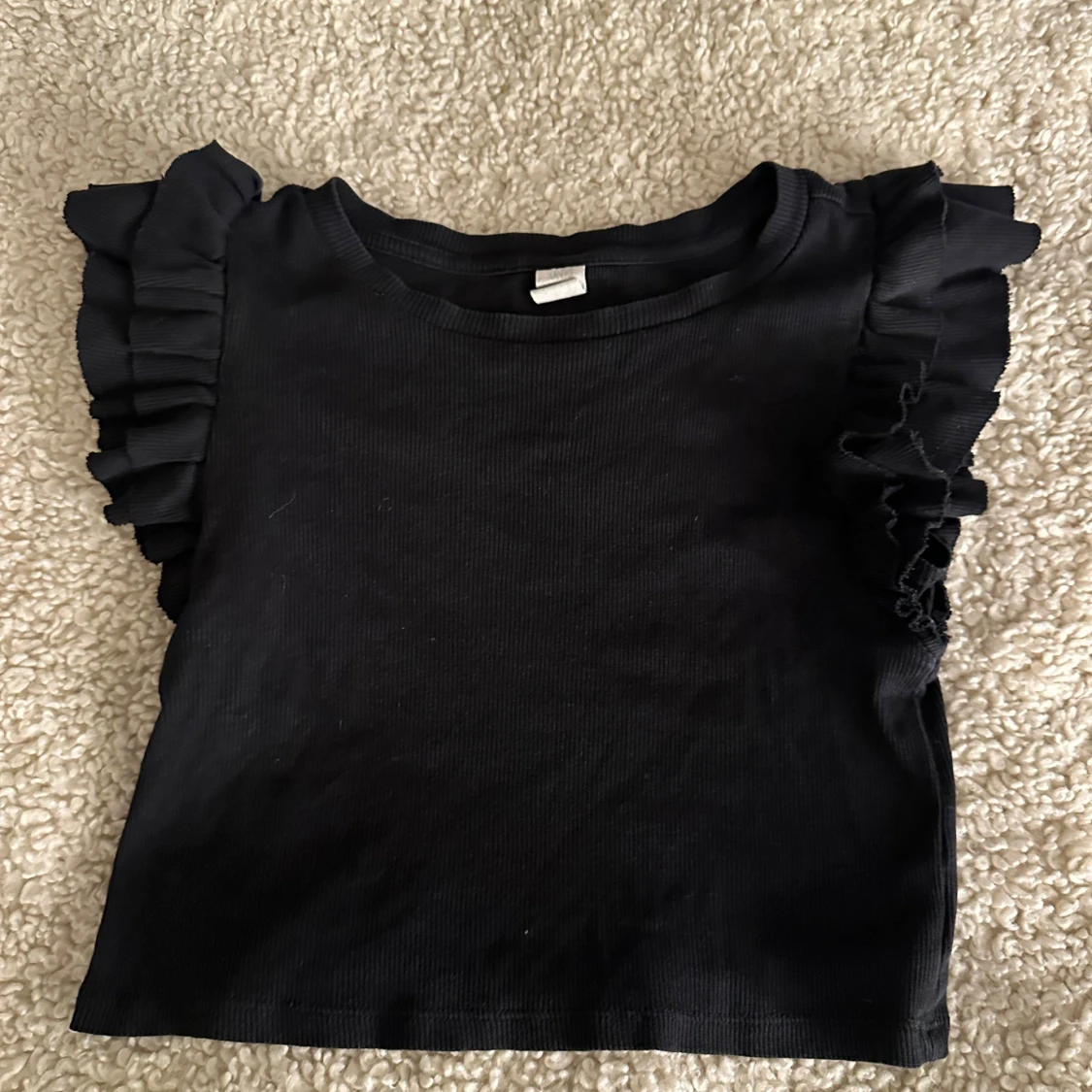 Svart ribbad topp med volangärmar