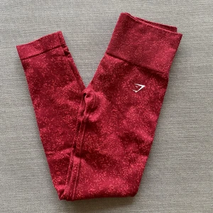 Röda leggings från Gymshark - Snygga röda leggings från Gymshark med diskret mönster. Stretchigt material som sitter tight och är perfekt för träning. Knappt använda och därav i superbra skick!💕