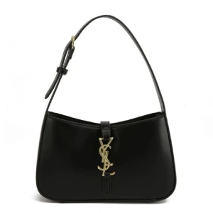 Svart axelväska från Yves Saint Laurent - Snygg svart axelväska från YSL med guldigt logospänne framtill. Väskan har en stilren, rektangulär form och justerbar axelrem. Tillverkad i slätt skinn med dragkedja upptill och detaljer i guld. Perfekt för dig som gillar lyxiga accessoarer.