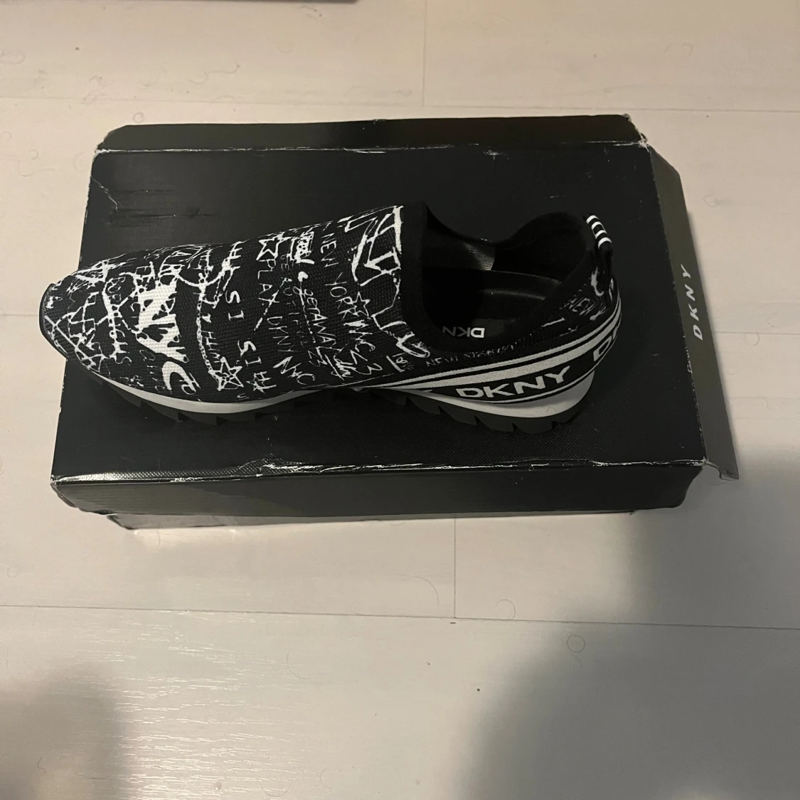 Svart-vita slip-on sneakers från DKNY - 1