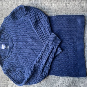 Mörkblå kabelstickad tröja Lands' End - Kabelstickad mörkblå tröja från Lands' End med rund halsringning och ribbade muddar. Klassisk och stilren modell i mjuk bomull, perfekt för lager-på-lager. Snygg struktur och normal passform, passar till allt. Postar snabbt!