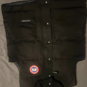 Canada Goose Väst - Säljer den åt min kusin då han bytte den med hans elscooter. Den är ny och förra ägaren säger att den är äkta. Den är varm och väldigt stilig. Hör av er vid minsta lilla!