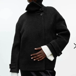 Svart skepparkavaj med hög krage - Svart kort kappa  från ARKET med hög krage som kan stängas med knappar. Jackan har en loose passform, långa ärmar och grov ullstruktur. Dubbelknäppt framtill och detaljer vid ärmslut. Perfekt för dig som gillar minimalistisk och stilren look. Jackan är HELT slutsåld och otroligt populär! Inhandlades för cirka 3000 kr, men jag säljer för billigare vid snabb affär!!💕✨