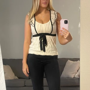 Rosa-vit blus med volang - Säljer en söt rosa-vit blus som är v-ringad. Storlek som passar xs och s. Lite skrynklig men blir slät om man stryker den. Använd sparsamt och i fint skick!😊