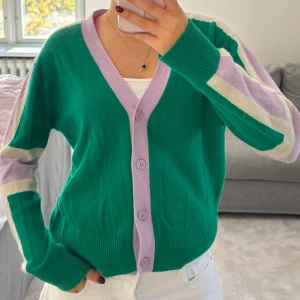 Kashmir kofta  - Superfin kofta i 100% kashmir från From Future. Grön bas med lila knappar och kant, samt lila och vita blockränder längs ärmarna. 