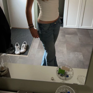 Lågmidjade ljusblå jeans bootcut - Säljer ett par snygga lågmidjade jeans i ljusblå tvätt med klassisk femficksdesign. Jeansen har bootcut-ben och sitter riktigt bra på höften. Perfekta för dig som gillar en avslappnad och trendig look. lite lösa och mjukt och skönt material, ganska tunna, bra under sommaren 
